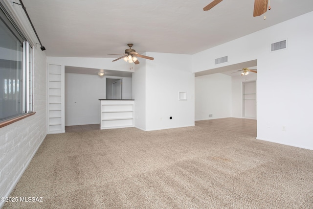 5930 E 32nd St, Tucson, AZ 85711 - unfurnished living room with visible vents, built in shelves, a ceiling fan, and carpet flooring
