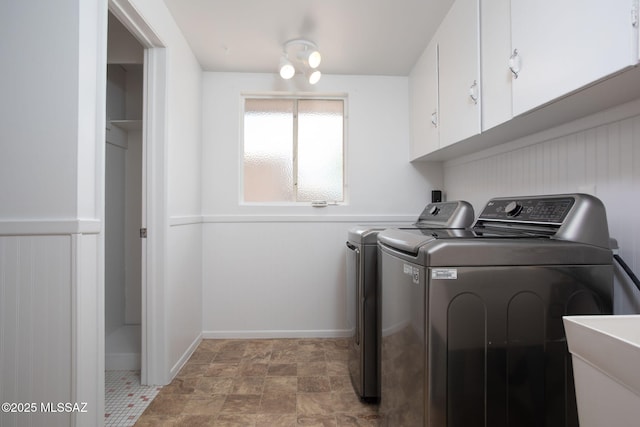 5930 E 32nd St, Tucson, AZ 85711 - washroom featuring stone finish floor, a sink, baseboards, washer and clothes dryer, and cabinet space