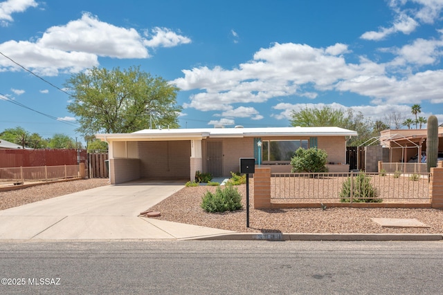 5930 E 32nd St, Tucson, AZ 85711 - ranch-style home with driveway, a fenced front yard, a carport, and brick siding