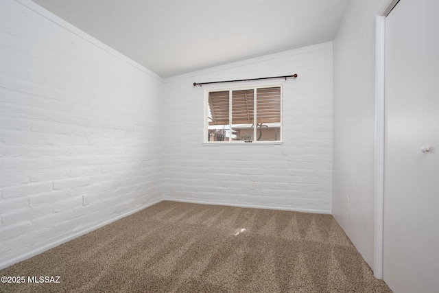 5930 E 32nd St, Tucson, AZ 85711 - carpeted empty room with lofted ceiling and brick wall