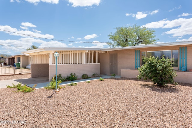 5930 E 32nd St, Tucson, AZ 85711 - view of front of home with a patio, fence, and brick siding
