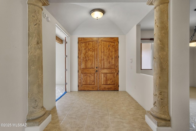 foyer with ornate columns, light tile patterned floors, and lofted ceiling
