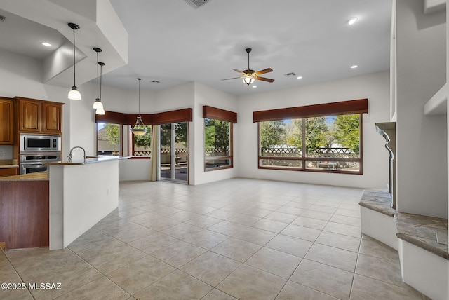unfurnished living room with visible vents, a sink, light tile patterned flooring, recessed lighting, and a ceiling fan