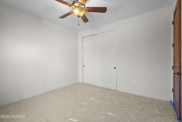 unfurnished bedroom featuring carpet floors, a ceiling fan, and a closet