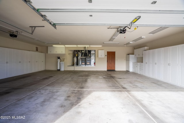garage featuring a garage door opener and freestanding refrigerator