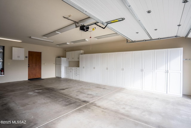 garage with a garage door opener and freestanding refrigerator