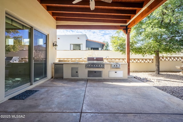 view of patio / terrace with fence, a ceiling fan, a sink, and area for grilling