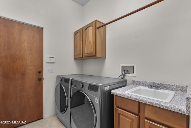 clothes washing area with washing machine and clothes dryer, light tile patterned floors, a sink, and cabinet space