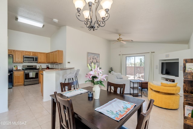 dining space with ceiling fan with notable chandelier, light tile patterned floors, and high vaulted ceiling
