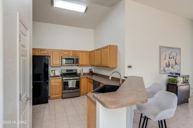 kitchen featuring appliances with stainless steel finishes, a sink, high vaulted ceiling, a peninsula, and light tile patterned floors