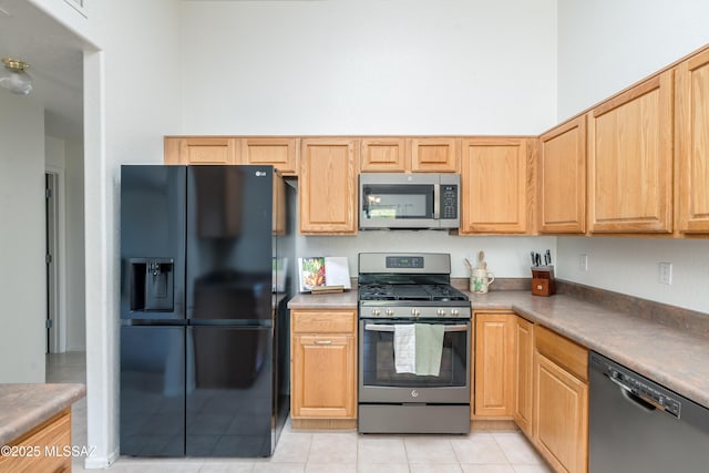 kitchen featuring stainless steel appliances and light tile patterned flooring