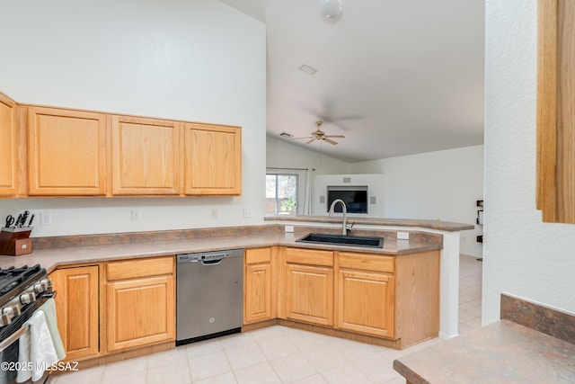 kitchen with a sink, a peninsula, lofted ceiling, a ceiling fan, and appliances with stainless steel finishes