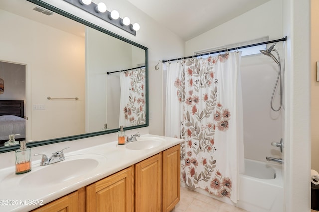 bathroom featuring a sink, tile patterned flooring, double vanity, and lofted ceiling