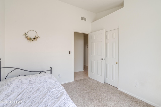 carpeted bedroom featuring visible vents, baseboards, vaulted ceiling, and a closet