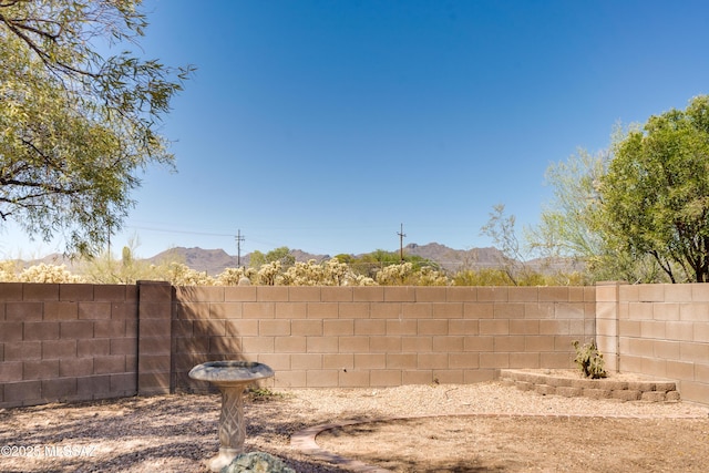 view of yard featuring a mountain view and a fenced backyard
