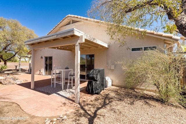 back of house with a patio and stucco siding