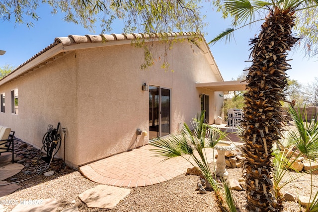 rear view of property with a patio area and stucco siding