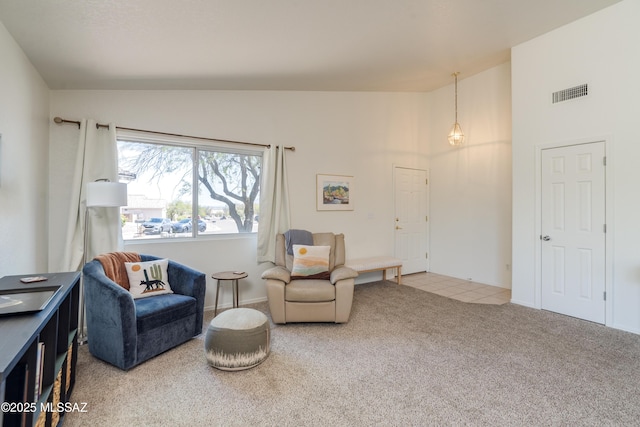living area featuring visible vents, carpet, and high vaulted ceiling