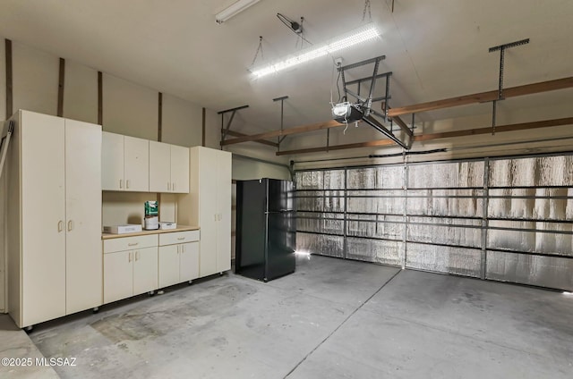 9290 N Jessy Ln, Tucson, AZ 85742 - garage featuring a garage door opener and freestanding refrigerator