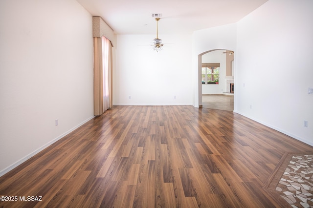 2377 W Catalina View Dr, Tucson, AZ 85742 - spare room featuring arched walkways, a ceiling fan, dark wood finished floors, and baseboards