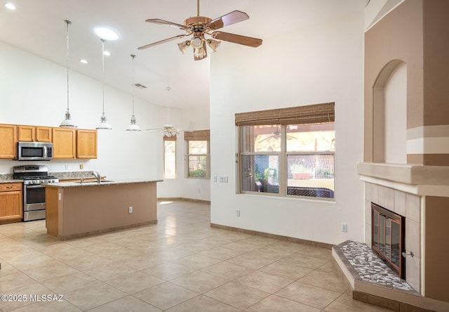 2377 W Catalina View Dr, Tucson, AZ 85742 - kitchen featuring stainless steel appliances, ceiling fan, high vaulted ceiling, a fireplace, and a sink