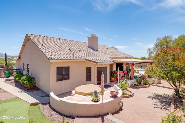 2377 W Catalina View Dr, Tucson, AZ 85742 - back of property with a patio area, a chimney, a tiled roof, stucco siding, and a putting green
