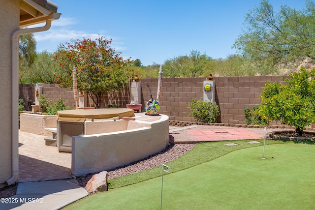 2377 W Catalina View Dr, Tucson, AZ 85742 - view of patio featuring an area to practice putting, a fenced backyard, and a hot tub