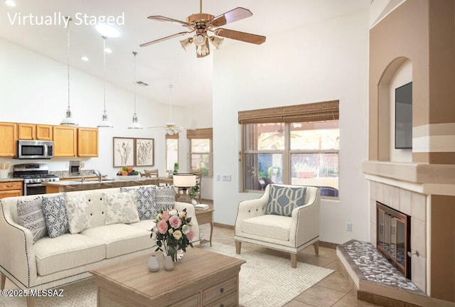 2377 W Catalina View Dr, Tucson, AZ 85742 - living area featuring ceiling fan, high vaulted ceiling, a tile fireplace, light tile patterned floors, and baseboards
