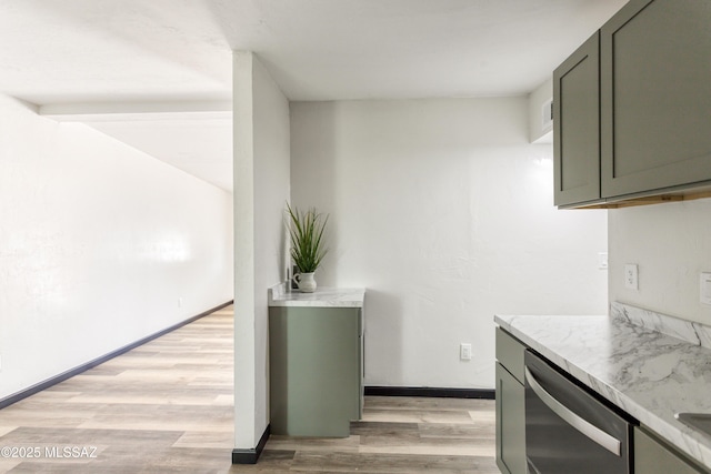kitchen featuring baseboards, stainless steel dishwasher, light wood-style flooring, and light stone counters