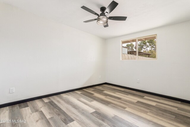 empty room with baseboards, wood finished floors, and ceiling fan