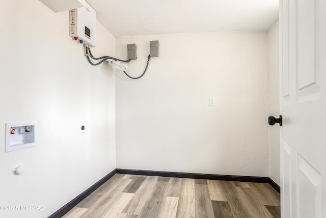 clothes washing area featuring baseboards, wood finished floors, washer hookup, and laundry area