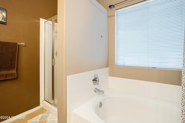 bathroom featuring tile patterned floors, a shower stall, and a bath