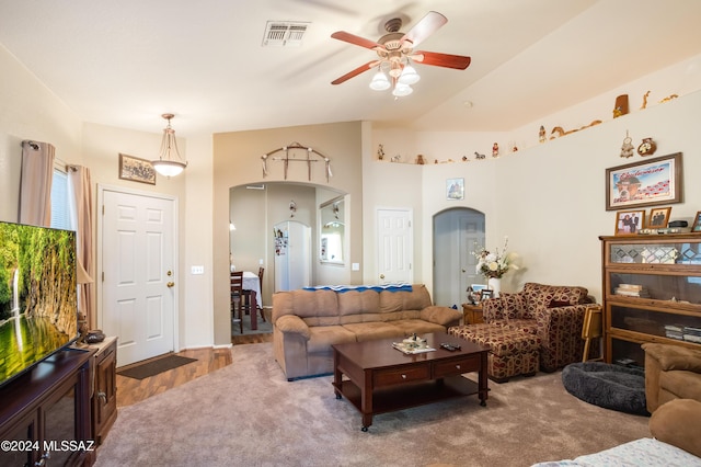 carpeted living room featuring arched walkways, visible vents, a ceiling fan, and lofted ceiling