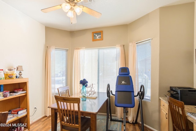 dining area with plenty of natural light, ceiling fan, baseboards, and light wood-type flooring