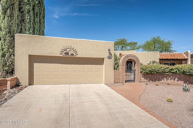 2778 S Via Del Bac, Green Valley, AZ 85622 - pueblo-style home featuring stucco siding, a gate, concrete driveway, and an attached garage