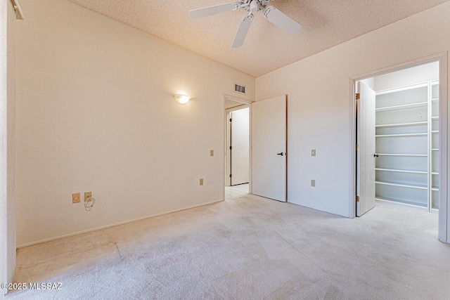 2778 S Via Del Bac, Green Valley, AZ 85622 - unfurnished bedroom with a textured ceiling, light colored carpet, visible vents, ceiling fan, and a walk in closet