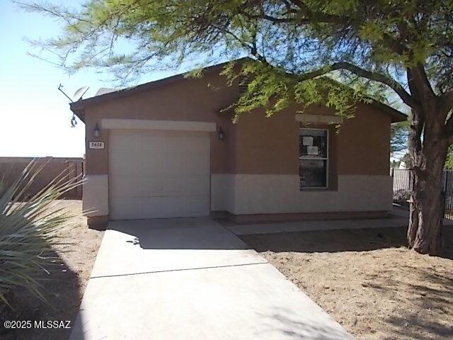 view of front facade with stucco siding, driveway, and an attached garage