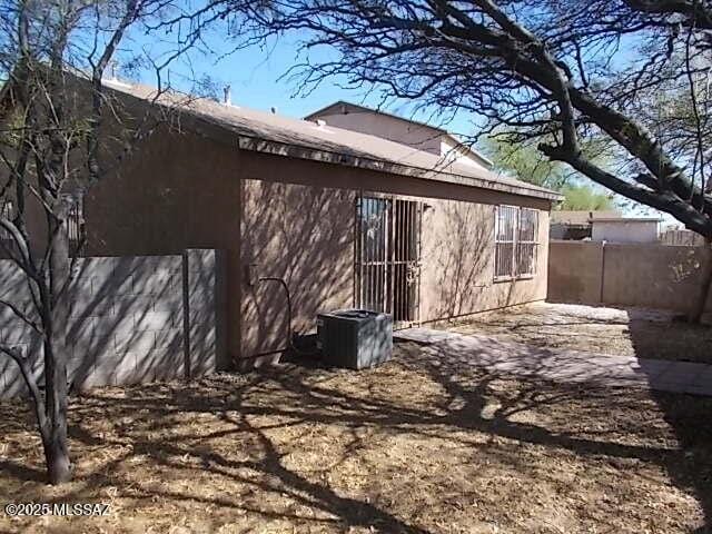 back of house with central AC, fence, and a patio