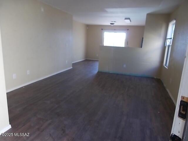 empty room featuring dark wood finished floors and baseboards