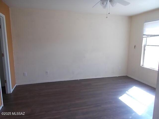 spare room featuring a ceiling fan, wood finished floors, and baseboards