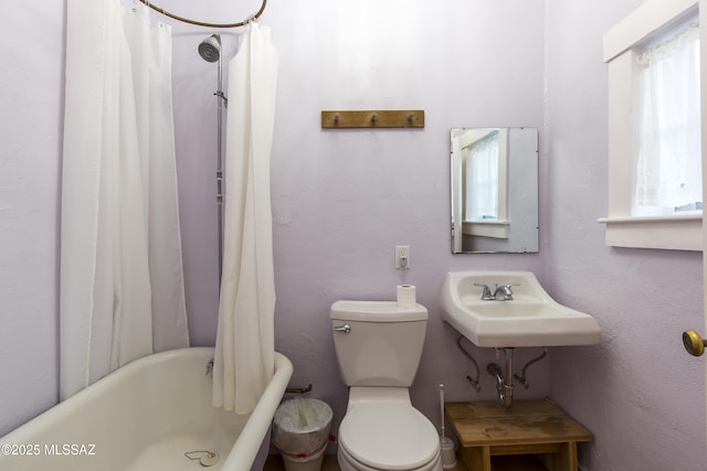 bathroom featuring toilet, a sink, and shower / tub combo