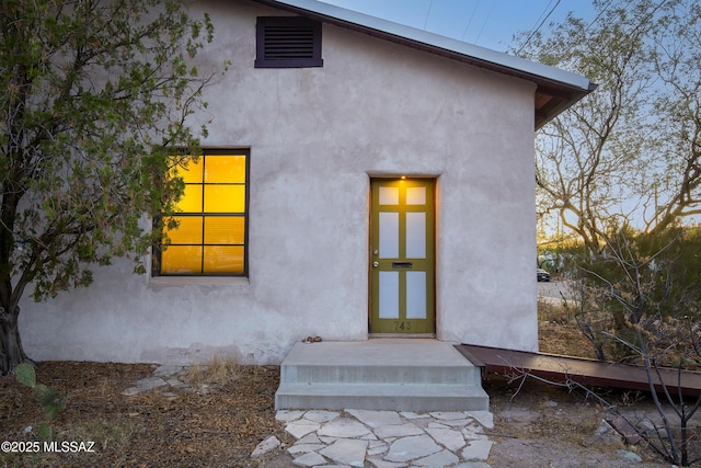 view of exterior entry with stucco siding