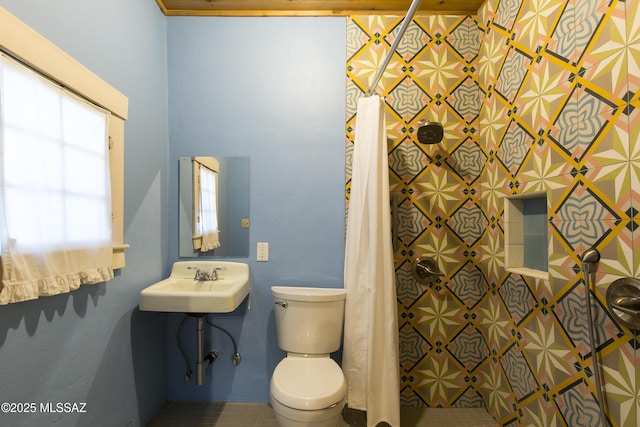 full bath featuring toilet, a sink, and curtained shower