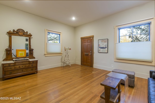 exercise area with recessed lighting, light wood finished floors, and baseboards