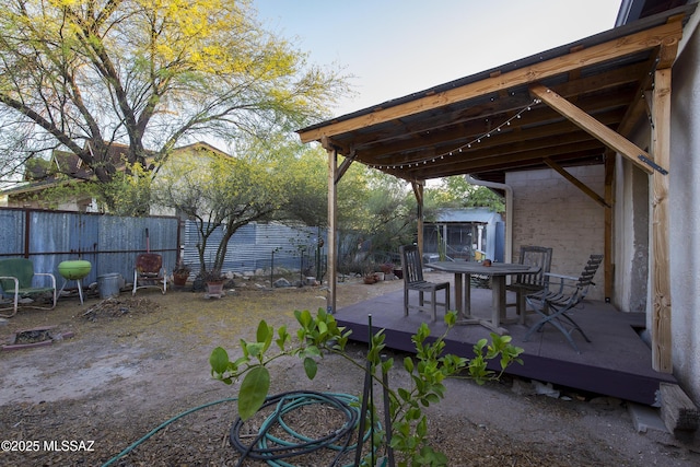 view of yard with outdoor dining space, a wooden deck, and a fenced backyard