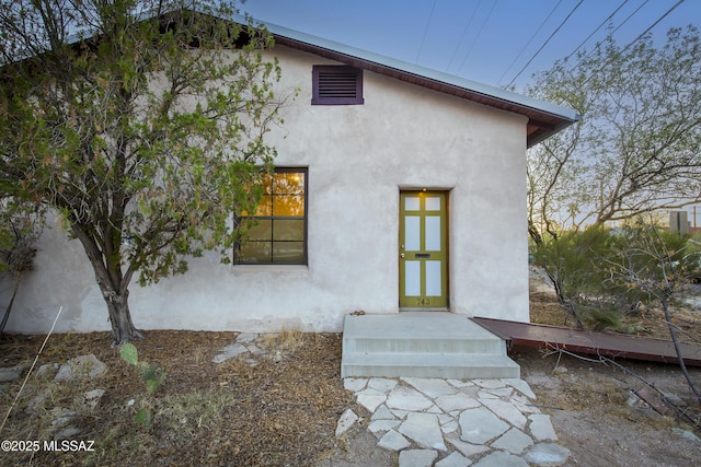 back of property featuring stucco siding