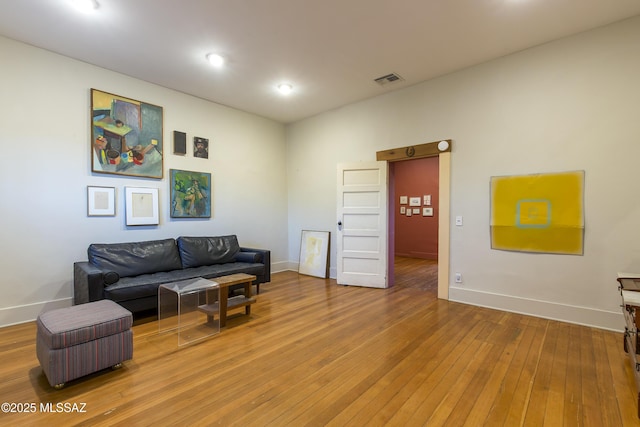 living room featuring recessed lighting, visible vents, baseboards, and light wood-type flooring