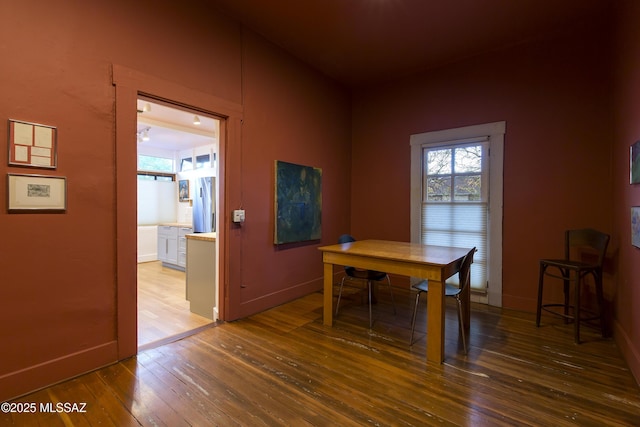 dining space with hardwood / wood-style flooring and baseboards