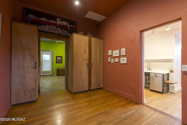 unfurnished room with light wood-type flooring and a sink
