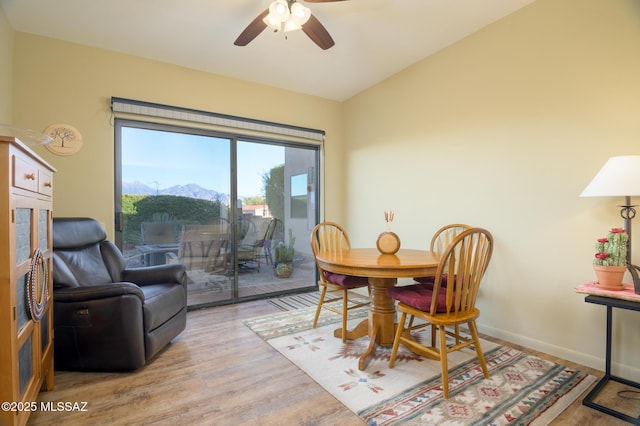 dining room featuring baseboards, ceiling fan, wood finished floors, and vaulted ceiling
